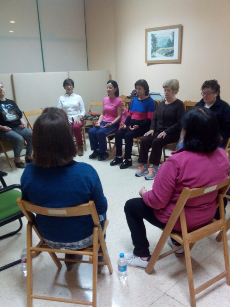 Grupo de personas practicando meditación sentadas en círculo